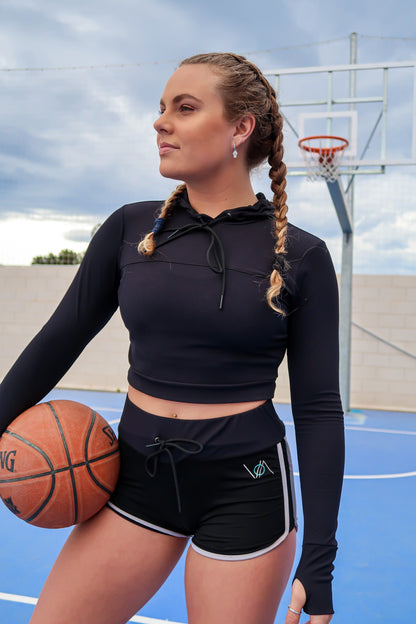 Girl with cropped hoodie holding basketball