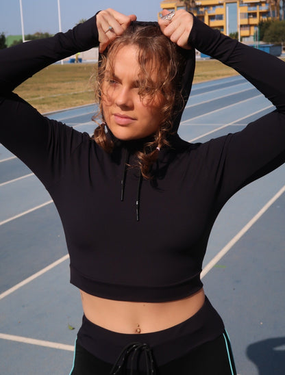 Girl with copped hoodie on running track
